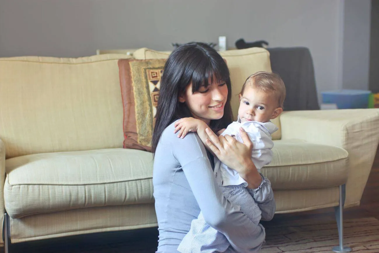 Una babysitter abbraccia teneramente un bambino sul divano di casa